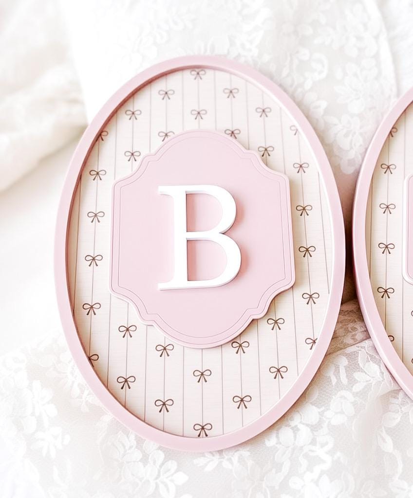 Pink decorative frame with a white letter 'B' on a textured white background