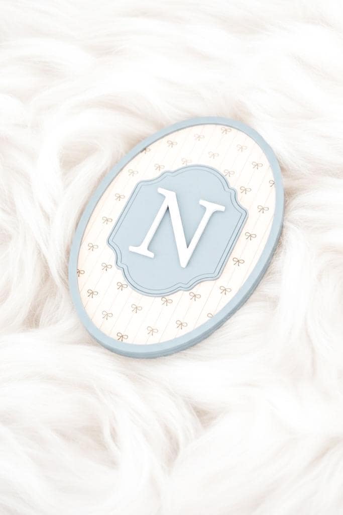 Decorative sign with letter 'N' on a soft white background